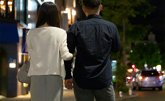 夜デートをするカップルの後ろ姿