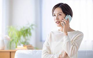 落ち着いた室内で電話相談をする女性