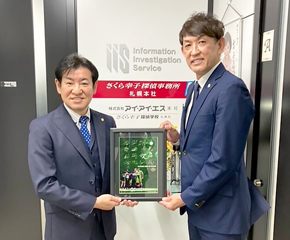 レバンガ北海道の折茂社長と、さくら幸子探偵事務所の代表山田聡との記念写真